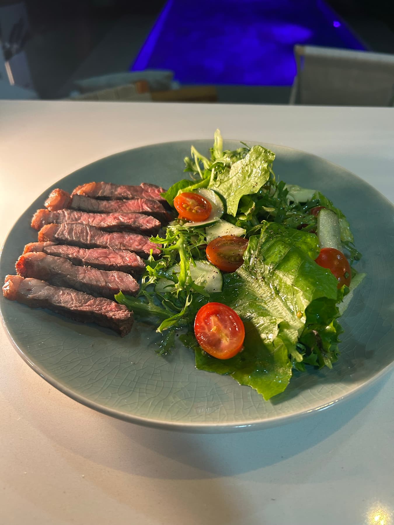 Bife con ensalada servido junto a la piscina